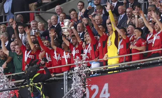 Manchester United's players celebrate with the trophy after winning the English FA Cup final soccer match between Manchester City and Manchester United at Wembley Stadium in London, Saturday, May 25, 2024. (AP Photo/Ian Walton)