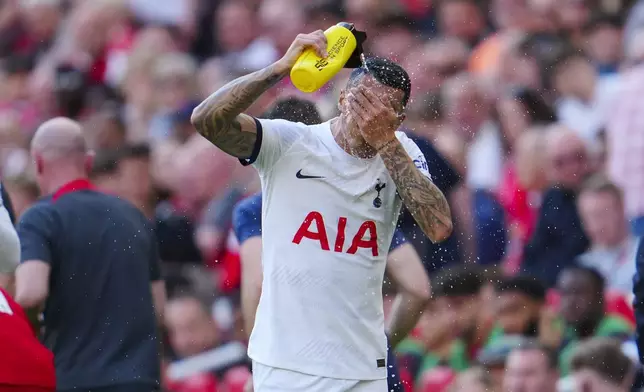 Tottenham's Pedro Porro splashes water on his face during the English Premier League soccer match between Liverpool and Tottenham Hotspur at Anfield Stadium in Liverpool, England, Sunday, May 5, 2024. (AP Photo/Jon Super)