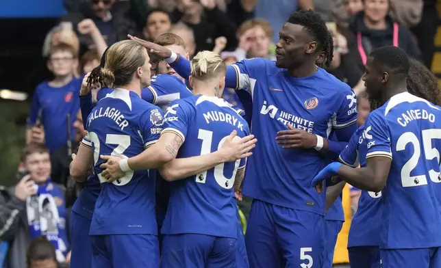 Chelsea players celebrate after Chelsea's Nicolas Jackson scored his side's fourth goal during the English Premier League soccer match between Chelsea and West Ham United at Stamford Bridge stadium in London, England, Sunday, May 5, 2024. (AP Photo/Frank Augstein)