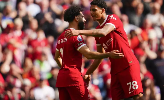 Liverpool's Mohamed Salah is congratulated by Jarell Quansah after scoring his side's opening goal during the English Premier League soccer match between Liverpool and Tottenham Hotspur at Anfield Stadium in Liverpool, England, Sunday, May 5, 2024. (AP Photo/Jon Super)