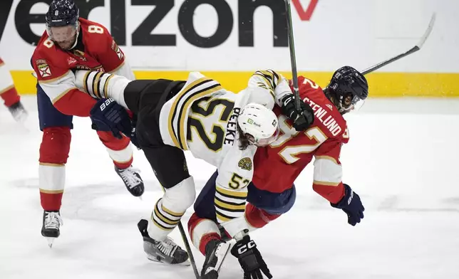 Boston Bruins defenseman Andrew Peeke (52) collides with Florida Panthers center Kevin Stenlund (82) and right wing Kyle Okposo (8) during the first period of Game 5 of the second-round series of the Stanley Cup Playoffs, Tuesday, May 14, 2024, in Sunrise, Fla. (AP Photo/Wilfredo Lee)