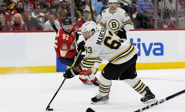 Boston Bruins left wing Brad Marchand (63) skates with the puck as Florida Panthers center Kevin Stenlund (82) defends during the first period of Game 2 of a second-round series of the NHL hockey Stanley Cup playoffs Wednesday, May 8, 2024, in Sunrise, Fla. (AP Photo/Lynne Sladky)