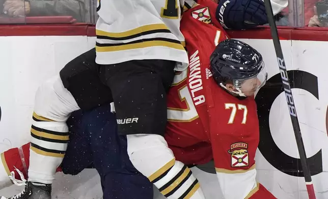 Boston Bruins center Charlie Coyle (13) and Florida Panthers defenseman Niko Mikkola (77) battle for the puck during the first period of Game 5 of the second-round series of the Stanley Cup Playoffs, Tuesday, May 14, 2024, in Sunrise, Fla. (AP Photo/Wilfredo Lee)