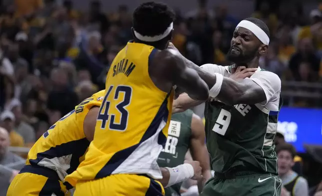 Milwaukee Bucks' Bobby Portis (9) shoves Indiana Pacers' Andrew Nembhard, left, during the first half of Game 4 of the first round NBA playoff basketball series, Sunday, April 28, 2024, in Indianapolis. (AP Photo/Michael Conroy)