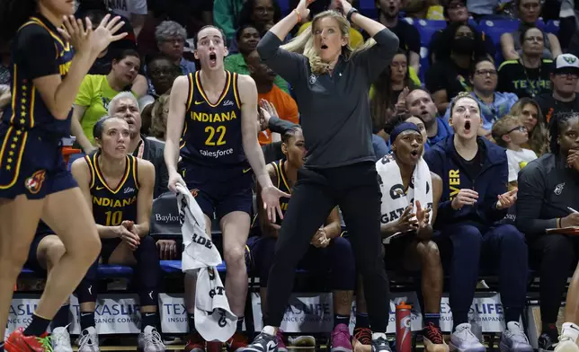 CORRECTS FROM CAITLYN TO CAITLIN - Indiana Fever guard Caitlin Clark (22) and head coach Christine Sides, center right, react after a play during the second half of an WNBA basketball game against the Dallas Wings in Arlington, Texas, Friday, May 3, 2024. (AP Photo/Michael Ainsworth)