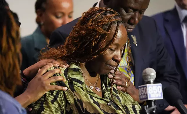 CORRECTS SERVICE BRANCH TO U.S. AIR FORCE INSTEAD OF U.S. NAVY - Chantemekki Fortson, mother of Roger Fortson, a U.S. Air Force senior airman, is comforted as she speaks about her son during a news conference regarding his death, with attorney Ben Crump, behind, Thursday, May 9, 2024, in Fort Walton Beach, Fla. Fortson was shot and killed by police in his apartment, May 3, 2024. (AP Photo/Gerald Herbert)