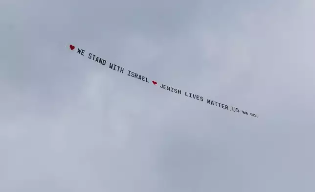A plane bearing a banner that reads ""We stand with Israel jewishlivesmatter.us" flies overhead before the University of Michigan's Spring 2024 Commencement Ceremony at Michigan Stadium in Ann Arbor, Mich., on Saturday, May 4, 2024. (Jacob Hamilton/Ann Arbor News via AP)