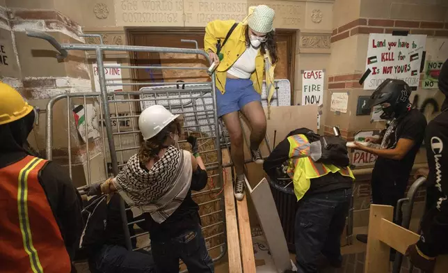 FILE - Pro-Palestinian demonstrators block the entrance to a building on the UCLA campus Wednesday, May 1, 2024, in Los Angeles. (AP Photo/Ethan Swope, File)