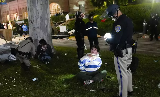 FILE - Demonstrators are detained by police in an encampment set up by pro-Palestinian demonstrators on the UCLA campus Thursday, May 2, 2024, in Los Angeles. (AP Photo/Jae C. Hong, File)