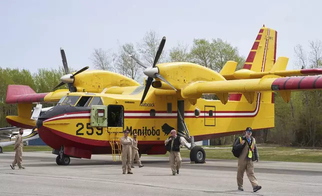 Firefighters arrive at the Flin Flon airport, as wildfires burn in northern Manitoba on Tuesday, May 14, 2024. (David Lipnowski/The Canadian Press via AP)