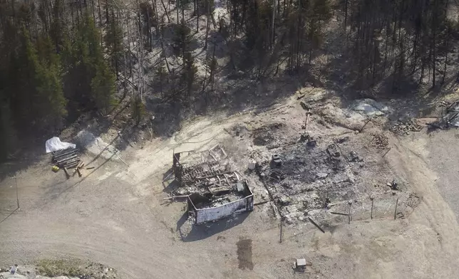 A cottage destroyed by wildfires burning in northern Manitoba, Canada, as seen from a helicopter on Tuesday, May 14, 2024. (David Lipnowski/The Canadian Press via AP)