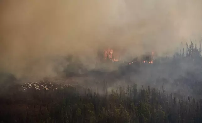 A wildfire burns in northern Manitoba near Flin Flon, as seen from a helicopter surveying the situation, Tuesday, May 14, 2024. (David Lipnowski/The Canadian Press via AP)