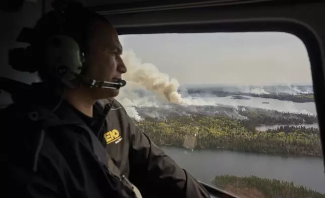 Manitoba Premier Wab Kinew surveys wildfires burning in northern Manitoba from a helicopter on Tuesday, May 14, 2024. (David Lipnowski/The Canadian Press via AP)