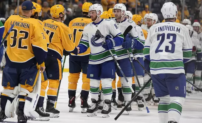 The Nashville Predators and Vancouver Canucks shake hands after Game 6 of an NHL hockey Stanley Cup first-round playoff series Friday, May 3, 2024, in Nashville, Tenn. The Canucks won 1-0 winning the series four games to two. (AP Photo/George Walker IV)