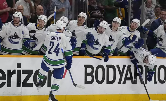 Vancouver Canucks center Pius Suter (24) celebrates his goal against the Nashville Predators with teammates during the third period in Game 6 of an NHL hockey Stanley Cup first-round playoff series Friday, May 3, 2024, in Nashville, Tenn. The Canucks won 1- 0. (AP Photo/George Walker IV)