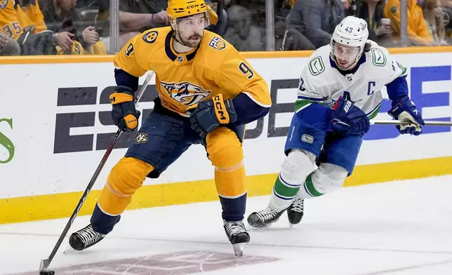 Nashville Predators left wing Filip Forsberg (9) skates the puck past Vancouver Canucks defenseman Quinn Hughes (43) during the second period in Game 6 of an NHL hockey Stanley Cup first-round playoff series Friday, May 3, 2024, in Nashville, Tenn. (AP Photo/George Walker IV)