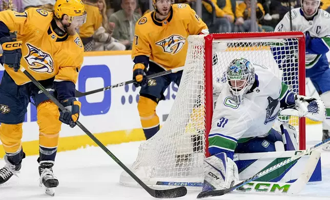 Vancouver Canucks goaltender Arturs Silovs (31) blocks a shot on goal by Nashville Predators center Mark Jankowski, left, during the second period in Game 6 of an NHL hockey Stanley Cup first-round playoff series Friday, May 3, 2024, in Nashville, Tenn. (AP Photo/George Walker IV)