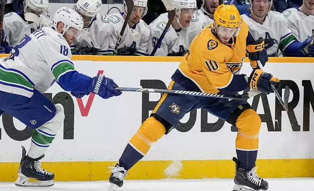 Nashville Predators center Colton Sissons (10) tries to get the puck past Vancouver Canucks center Sam Lafferty (18) during the first period in Game 6 of an NHL hockey Stanley Cup first-round playoff series Friday, May 3, 2024, in Nashville, Tenn. (AP Photo/George Walker IV)