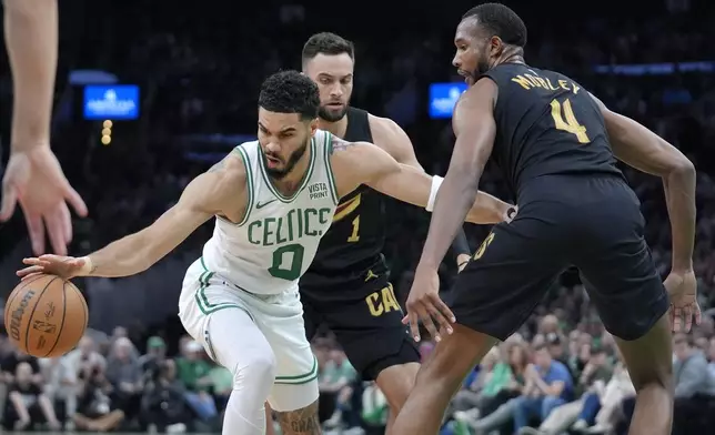 Boston Celtics forward Jayson Tatum, left, is defended by Cleveland Cavaliers guard Max Strus, behind, and forward Evan Mobley during the first half of Game 2 of an NBA basketball second-round playoff series Thursday, May 9, 2024, in Boston. (AP Photo/Steven Senne)