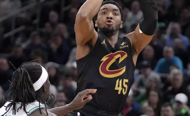 Cleveland Cavaliers guard Donovan Mitchell (45) shoots next to Boston Celtics guard Jrue Holiday (4) during the second half of Game 2 of an NBA basketball second-round playoff series Thursday, May 9, 2024, in Boston. (AP Photo/Steven Senne)