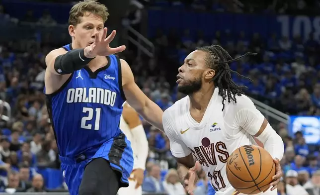 Cleveland Cavaliers guard Darius Garland, right, drives past Orlando Magic center Moritz Wagner (21) during the first half of Game 6 of an NBA basketball first-round playoff series, Friday, May 3, 2024, in Orlando, Fla. (AP Photo/John Raoux)