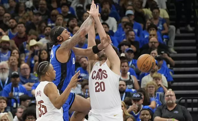 Orlando Magic forward Paolo Banchero loses the ball as he gets caught between Cleveland Cavaliers forward Isaac Okoro, left, and forward Georges Niang (20) during the first half of Game 6 of an NBA basketball first-round playoff series, Friday, May 3, 2024, in Orlando, Fla. (AP Photo/John Raoux)