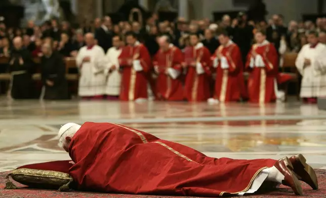 FILE - Pope Benedict XVI lies on the ground before the altar during a Good Friday ceremony for the Passion of Christ, inside St. Peter's Basilica at the Vatican, Friday, April 6, 2007. (AP Photo/Danilo Schiavella, Pool, File)