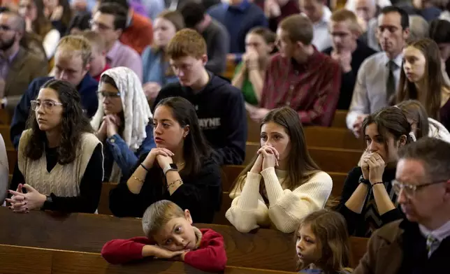 Catholics pray during Mass at Benedictine College Sunday, Dec. 3, 2023, in Atchison, Kan. (AP Photo/Charlie Riedel)