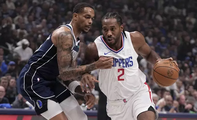 Dallas Mavericks forward P.J. Washington, left, defends as Los Angeles Clippers' Kawhi Leonard (2) works to the basket during the first half of Game 2 of an NBA basketball first-round playoff series Friday, April 26, 2024, in Dallas. (AP Photo/Tony Gutierrez)