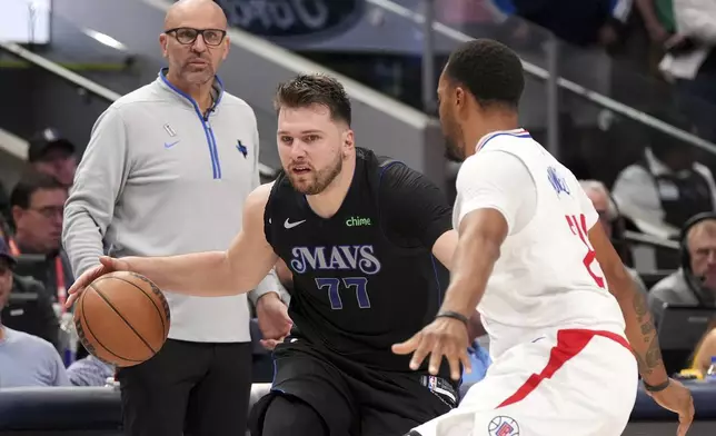 Dallas Mavericks guard Luka Doncic (77) tries to dribble past Los Angeles Clippers guard Norman Powell, right, as Mavericks' head coach Jason Kidd looks on during the second half of an NBA basketball first-round playoff series Friday, May 3, 2024, in Dallas. (AP Photo/Jeffrey McWhorter)