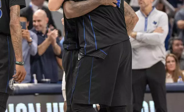 Dallas Mavericks guard Luka Doncic (77) embraces guard Kyrie Irving after Irving hit a 3-point basket late in the fourth quarter of an NBA basketball first-round playoff series against the Los Angeles Clippers Friday, May 3, 2024, in Dallas. (AP Photo/Jeffrey McWhorter)