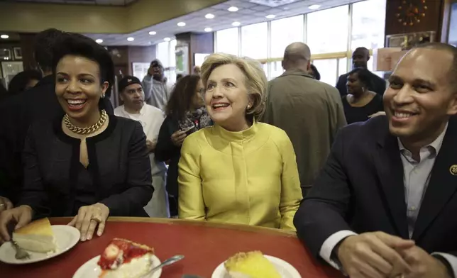 FILE - Democratic presidential candidatel Hillary Clinton, center, talks with Rep. Hakeem Jeffries, D-N.Y., right, and Council Member Laurie Cumbo as she sits at the counter of Junior's restaurant in the Brooklyn borough of New York, April 9, 2016. (AP Photo/Seth Wenig, File)