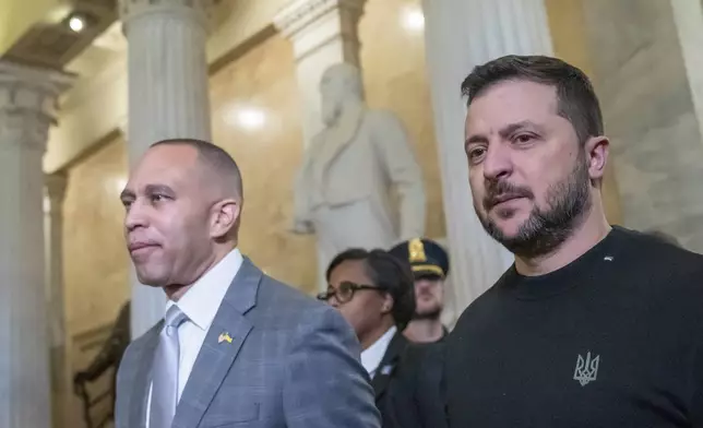 FILE - House Minority Leader Hakeem Jeffries of N.Y., left, walks with Ukrainian President Volodymyr Zelenskyy in the U.S. Capitol to a meeting with other congressional leaders, Dec. 12, 2023, in Washington. (AP Photo/Alex Brandon, File)