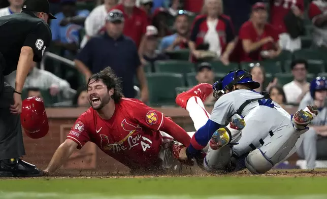 St. Louis Cardinals' Alec Burleson, left, scores past Chicago Cubs catcher Miguel Amaya during the eighth inning of a baseball game Saturday, May 25, 2024, in St. Louis. (AP Photo/Jeff Roberson)