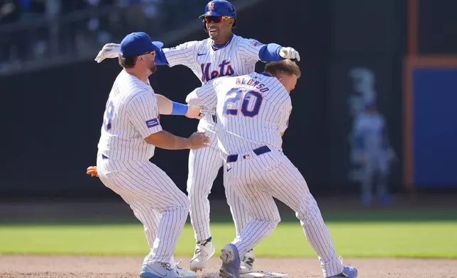 New York Mets' Francisco Lindor, center, celebrates with teammates after hitting a walk-off two-run double during the 11th inning of a baseball game against the Chicago Cubs at Citi Field, Thursday, May 2, 2024, in New York. The Mets defeated the Cubs 7-6 in 11 innings. (AP Photo/Seth Wenig)