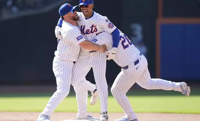 New York Mets' Francisco Lindor, center, celebrates with teammates DJ Stewart, left, and Pete Alonso after hitting a walk-off two-run double during the 11th inning of a baseball game against the Chicago Cubs at Citi Field, Thursday, May 2, 2024, in New York. The Mets defeated the Cubs 7-6 in 11 innings. (AP Photo/Seth Wenig)