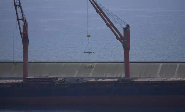 A crane loads food aid for Gaza onto the container ship Sagamore docked at Larnaca port, Cyprus, Wednesday, May 8, 2024. (AP Photo/Petros Karadjias)