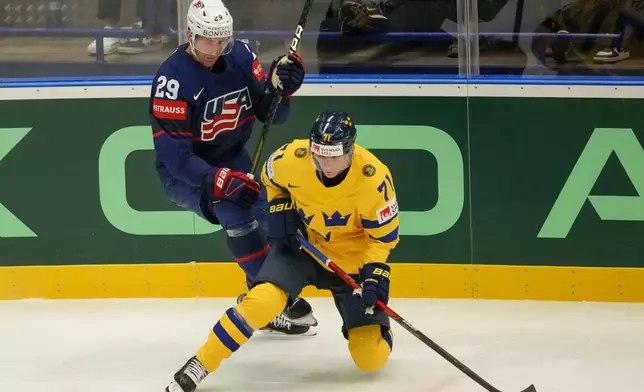 Sweden's Victor Olofsson, front, challenges for a puck with Unted States' Brock Nelson during the preliminary round match between Sweden and United States at the Ice Hockey World Championships in Ostrava, Czech Republic, Friday, May 10, 2024. (AP Photo/Darko Vojinovic)