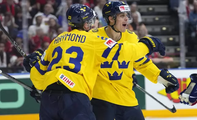 Sweden's Joel Erikson Ek, right, celebrates with Sweden's Lucas Raymomd after scoring his sides third goal during the semifinal match between Czech Republic and Sweden at the Ice Hockey World Championships in Prague, Czech Republic, Saturday, May 25, 2024. (AP Photo/Petr David Josek)