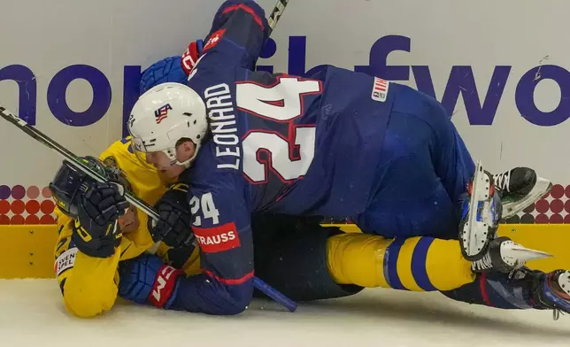 Unted States' Ryan Leonard, top, challenges with Sweden's Jonas Brodin during the preliminary round match between Sweden and United States at the Ice Hockey World Championships in Ostrava, Czech Republic, Friday, May 10, 2024. (AP Photo/Darko Vojinovic)