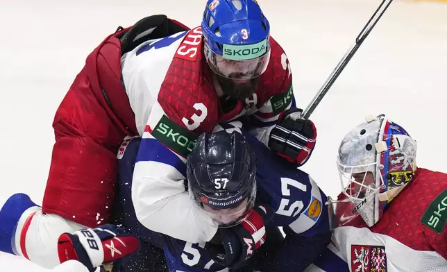Czech Republic's Radko Gudas, center top, checks Finland's Arttu Hyry, center, as Czech Republic's goalkeeper Lukas Dostal makes a save during the preliminary round match between Czech Republic and Finland at the Ice Hockey World Championships in Prague, Czech Republic, Friday, May 10, 2024. (AP Photo/Petr David Josek)