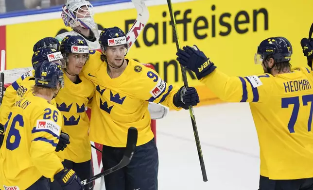 Sweden's Joel Erikson Ek celebrates with teammates after scoring his side's third goal during the semi final match between Sweden and Czech Republic at the Ice Hockey World Championships in Prague, Czech Republic, Saturday, May 25, 2024. (AP Photo/Darko Vojinovic)