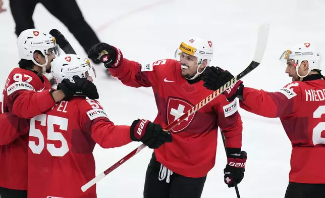 Switzerland's Romain Loeffel, 2nd left, celebrates with teammates after scoring his sides second goal during the preliminary round match between Switzerland and Norway at the Ice Hockey World Championships in Prague, Czech Republic, Friday, May 10, 2024. (AP Photo/Petr David Josek)