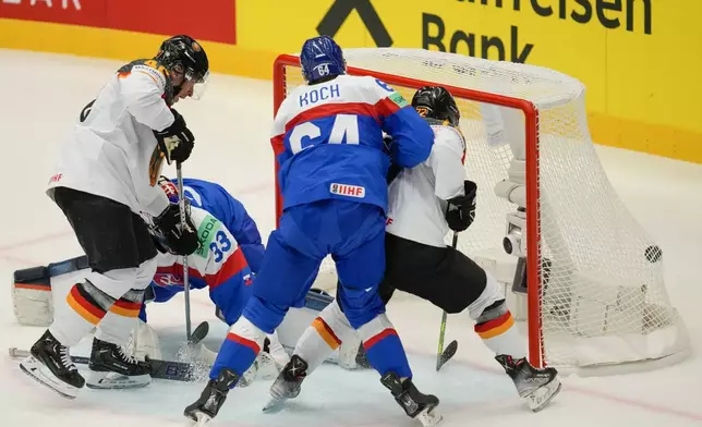 Germany's Dominik Kahun, right, scores his side's opening goal during the preliminary round match between Slovakia and Germany at the Ice Hockey World Championships in Ostrava, Czech Republic, Friday, May 10, 2024. (AP Photo/Darko Vojinovic)