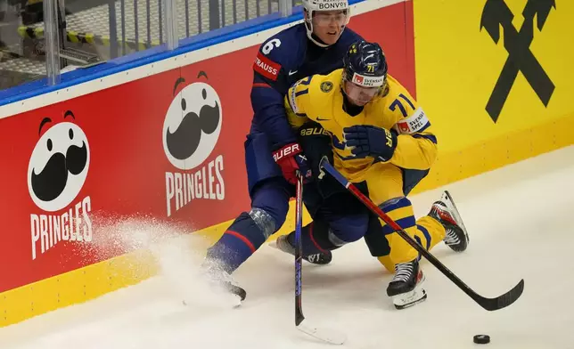 Sweden's Victor Olofsson, front, challenges for a puck with Unted States' Will Smith during the preliminary round match between Sweden and United States at the Ice Hockey World Championships in Ostrava, Czech Republic, Friday, May 10, 2024. (AP Photo/Darko Vojinovic)