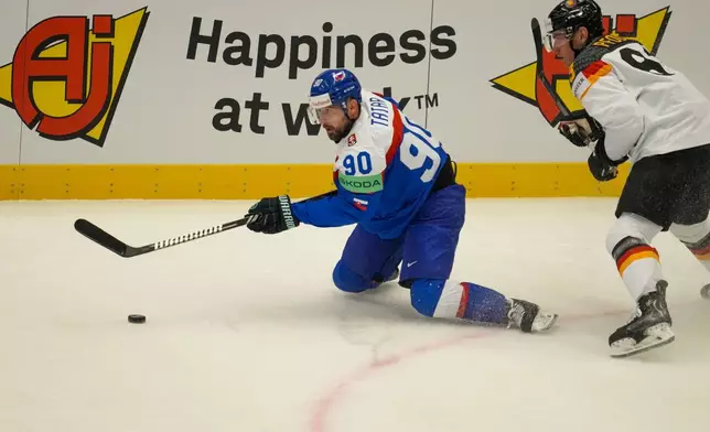 Slovakia's Tomas Tatar, left, challenges for a puck with Germany's Leonhard Pfoderl during the preliminary round match between Slovakia and Germany at the Ice Hockey World Championships in Ostrava, Czech Republic, Friday, May 10, 2024. (AP Photo/Darko Vojinovic)