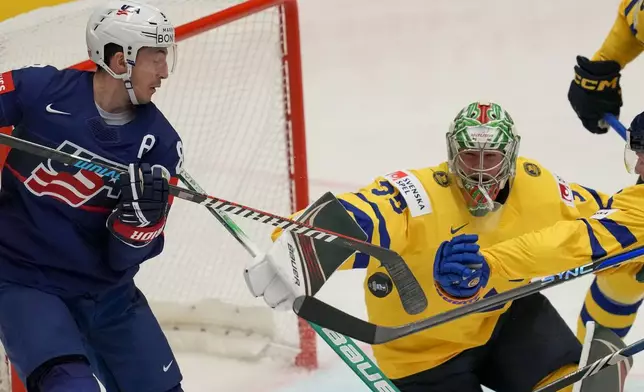 Sweden's goalkeeper Filip Gustavsson, right, makes a save in front of Unted States' Zach Werenski, left, during the preliminary round match between Sweden and United States at the Ice Hockey World Championships in Ostrava, Czech Republic, Friday, May 10, 2024. (AP Photo/Darko Vojinovic)