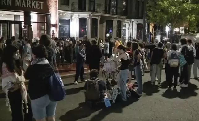 In this grab taken from video, protestors protesting the Israel-Hamas war stand outside near the campus of George Washington University, in Washington, Wednesday, May 8, 2024. Tensions have continued to ratchet up in standoffs with protesters on campuses across the U.S. and increasingly, in Europe, nearly three weeks into a movement launched by a protest at Columbia University. (WJLA via AP)
