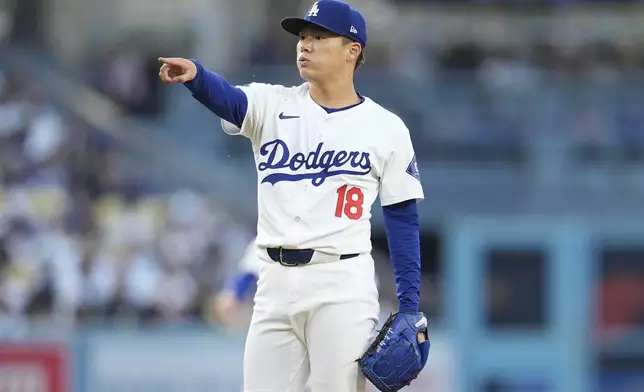 Los Angeles Dodgers starting pitcher Yoshinobu Yamamoto points to the home plate umpire during the first inning of a baseball game against the Arizona Diamondbacks, Monday, May 20, 2024, in Los Angeles. (AP Photo/Marcio Jose Sanchez)