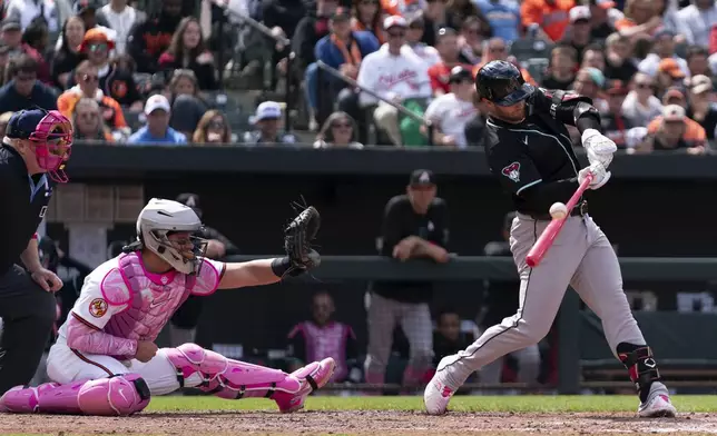 Arizona Diamondbacks' Christian Walker, right, hits during a baseball game against the Baltimore Orioles, Sunday, May 12, 2024, in Baltimore. (AP Photo/Jose Luis Magana)